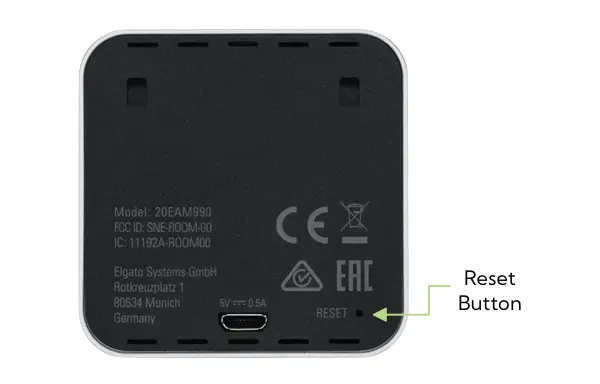 A photo showing the back of the Eve Room, with an arrow pointing to the reset button to the right of the charging port.