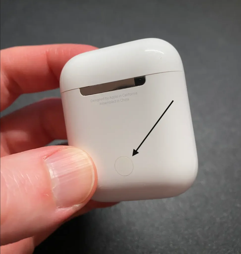Photo showing the reset button on the back of the Airpods case.